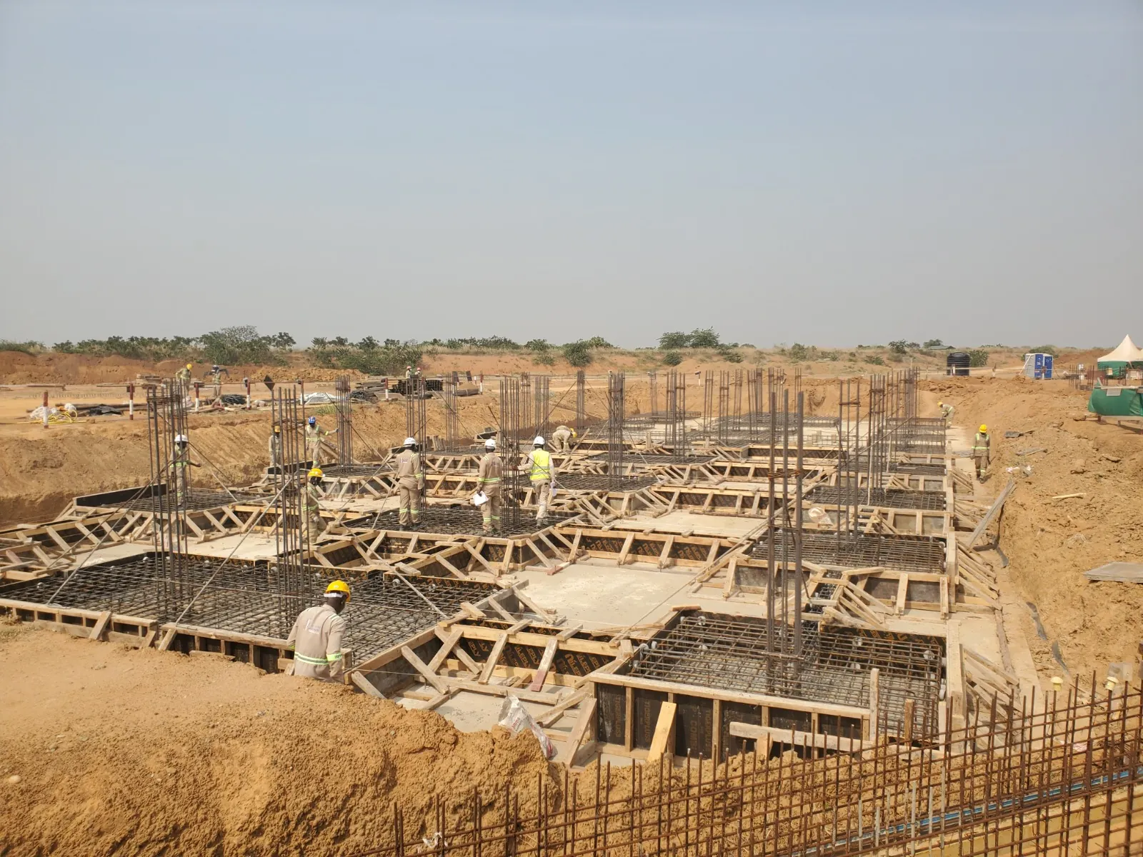 Active construction site with foundation reinforcement and site teams